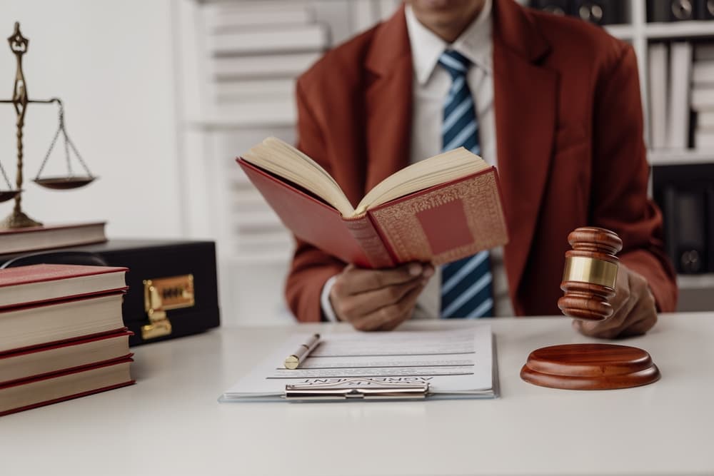 The scales of justice with a lawyer in the background. Jurisdiction concept: a lawyer reading the statute of limitations. A consultation between a male lawyer and a client.
