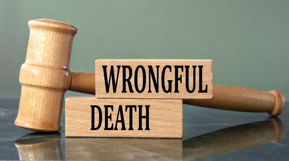 The image of the words "WRONGFUL DEATH" on wooden blocks, with a judge's gavel in the background, representing the legal context and gravity of wrongful death cases.