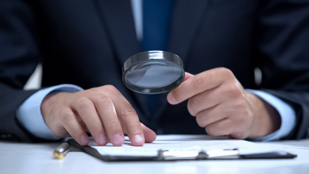 Lawyer examining a document with a magnifying glass, carefully analyzing the case details and conducting a thorough investigation.