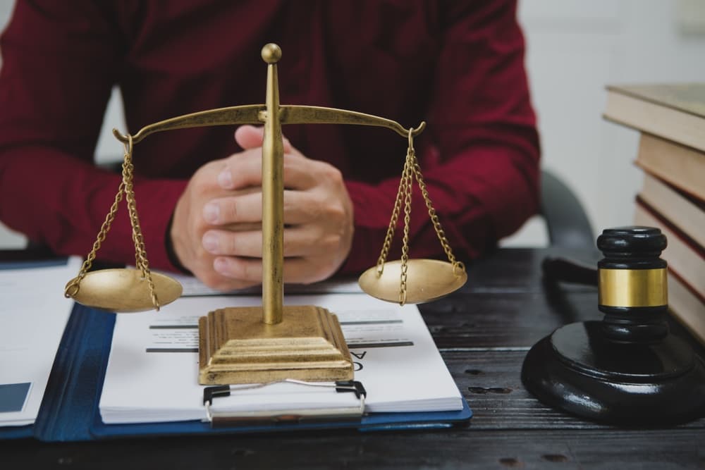 male lawyer meticulously reviews legal documents, ensuring accuracy and compliance for an upcoming court case. 