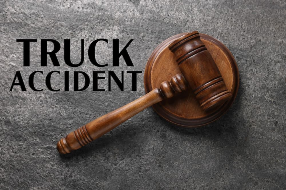 Truck accident law. Judge's gavel on grey table, top view
