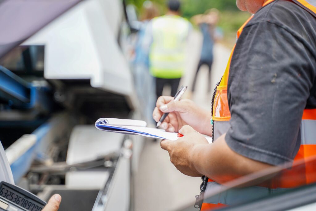 Investigator examines truck data with clipboard, likely reviewing black box records after an accident.