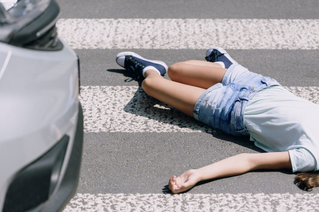 Injured pedestrian lying on a crosswalk near a vehicle, illustrating pedestrian accident risks in the San Ysidro Port of Entry area